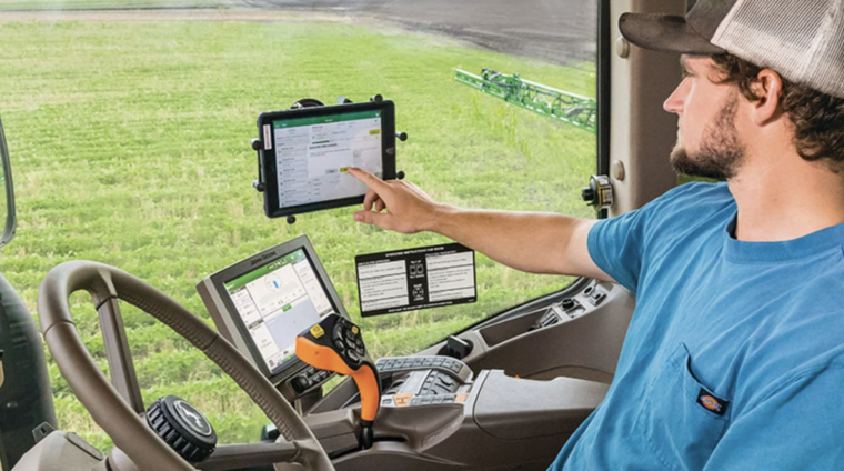 Farmer using John Deere precision technology out in the field